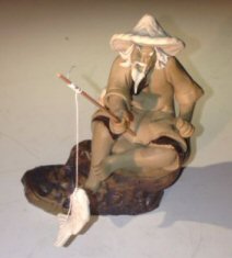 Ceramic Figurine -Mud Man Sitting On A Rock Fishing -