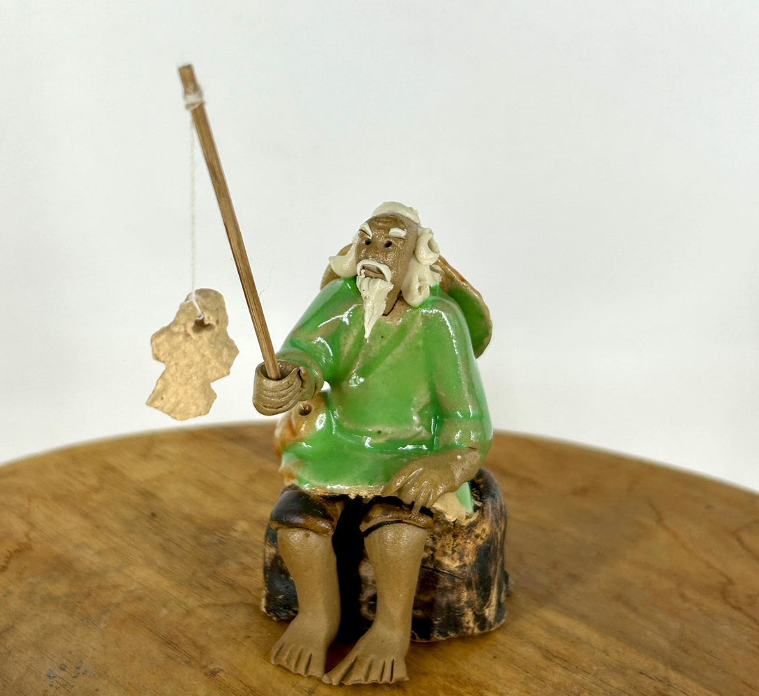 Miniature Ceramic Glazed Fisherman Figurine-Sitting On A Log -Light Green - 2.5