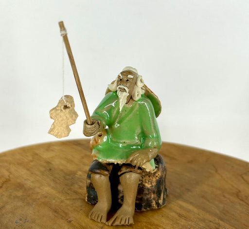 Miniature Ceramic Glazed Fisherman Figurine-Sitting On A Log -Light Green - 2.5