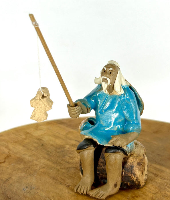Miniature Ceramic Glazed Fisherman Figurine-Sitting On A Log -Light Blue - 2.5